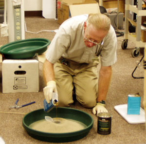Paul Doherty pours the stirred polyurethane foam mixture into a plastic cup